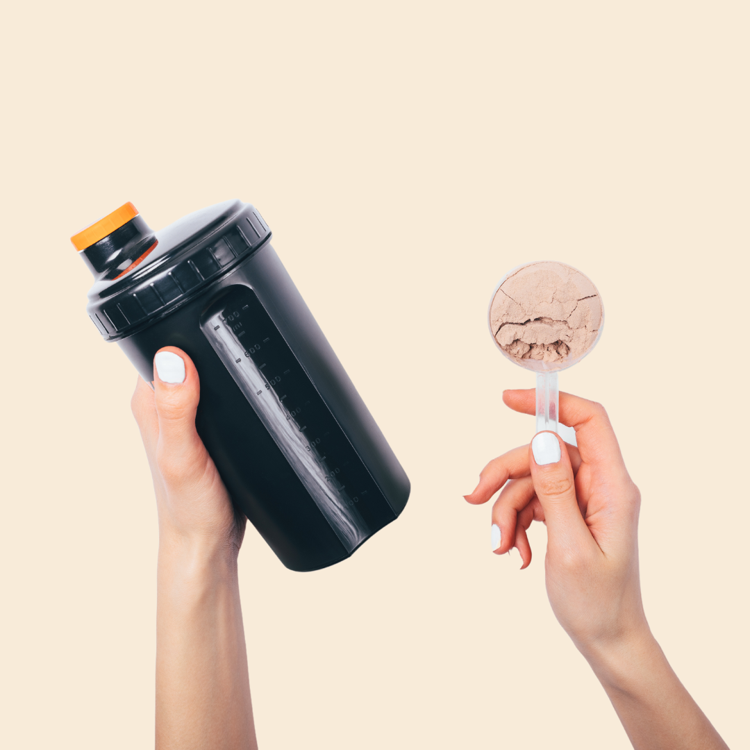 Hands holding a black shaker bottle and a scoop of protein powder
