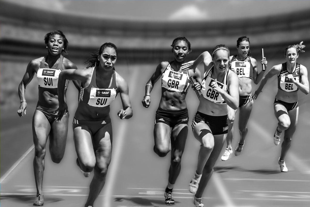 Relay runners passing a baton on a running track