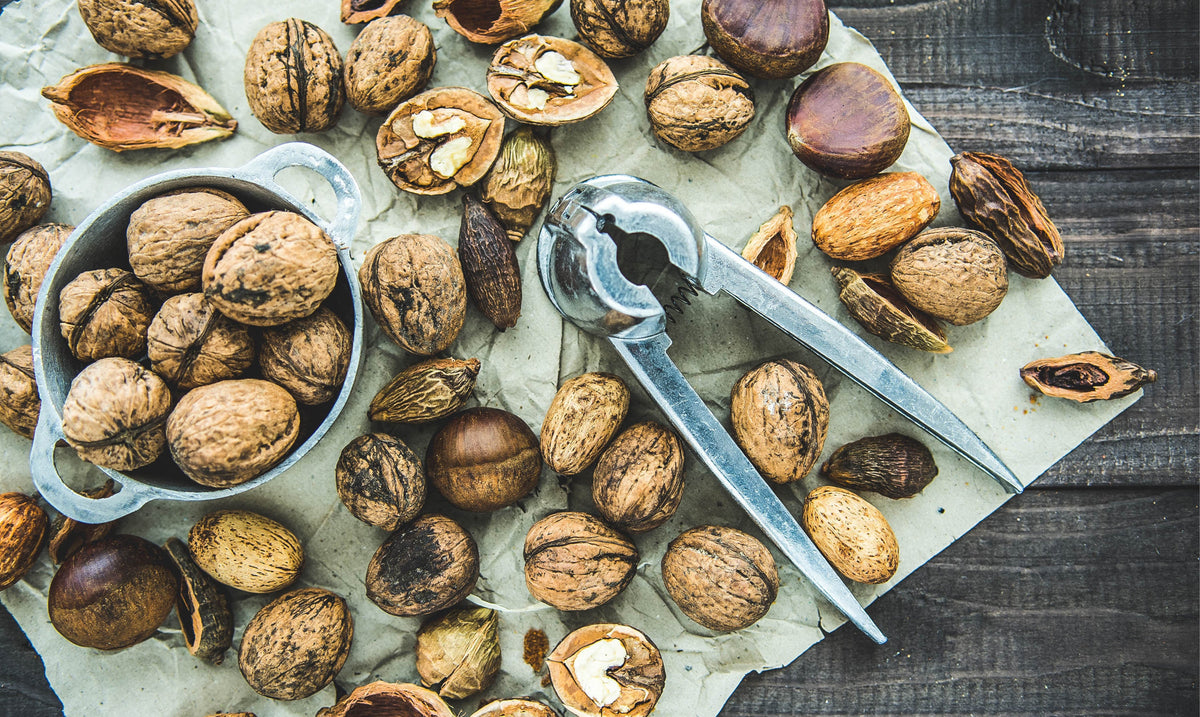 Walnuts in their shells with a nutcracker on a wooden table